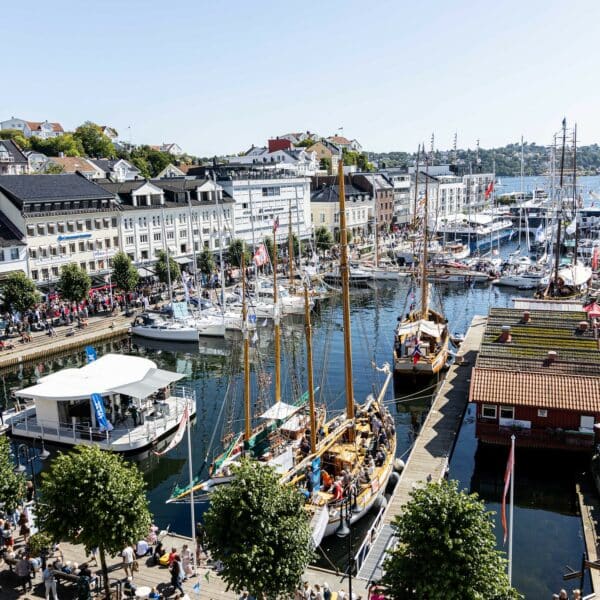 Bilde av havna i Arendal under Arendalsuka, med mange båter og masse folk.